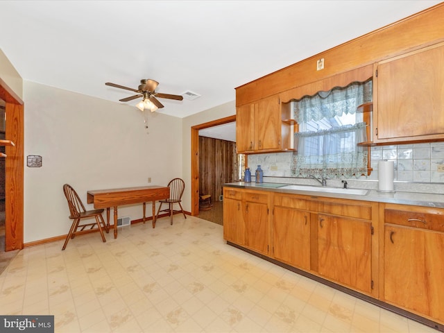 kitchen featuring light floors, a sink, visible vents, and decorative backsplash