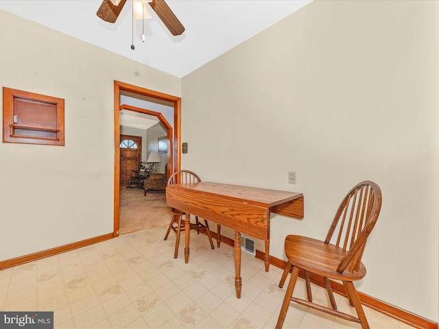 dining space featuring a ceiling fan, visible vents, baseboards, and light floors