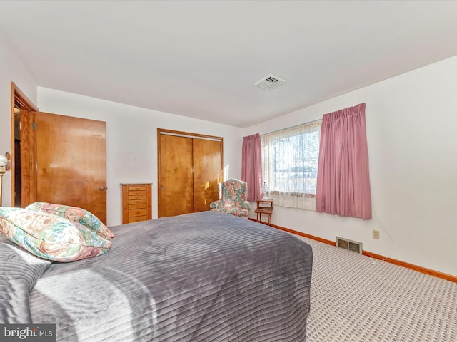 bedroom with baseboards, a closet, visible vents, and carpet flooring