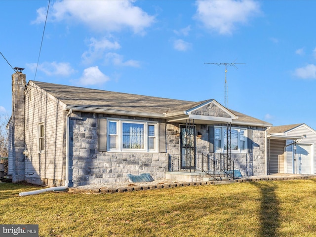 single story home featuring stone siding, a front lawn, a chimney, and roof with shingles