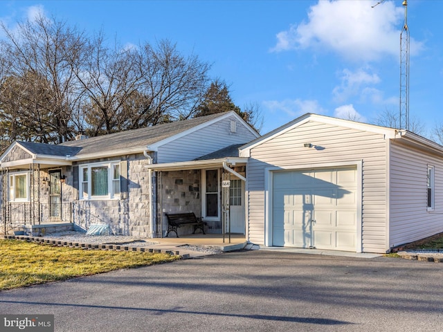 view of front of property featuring a garage and stone siding