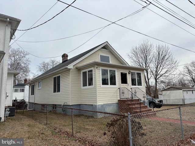 view of front of home featuring fence and a chimney