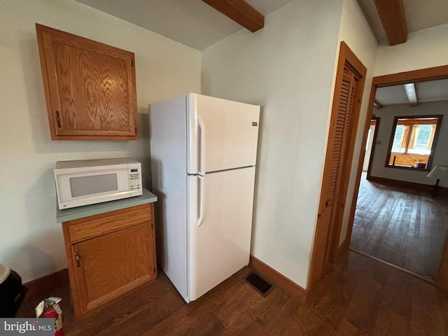 kitchen with dark wood-style floors, white appliances, brown cabinetry, and beam ceiling