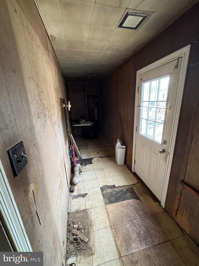 doorway featuring wooden walls