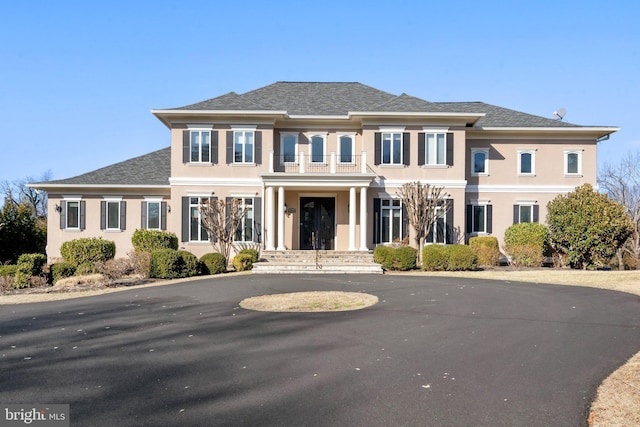 view of front of property featuring roof with shingles and stucco siding