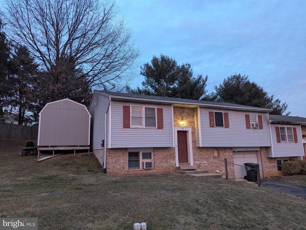 split foyer home with entry steps, driveway, a shed, and brick siding