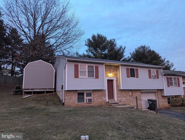 raised ranch with entry steps, a shed, a front yard, and aphalt driveway