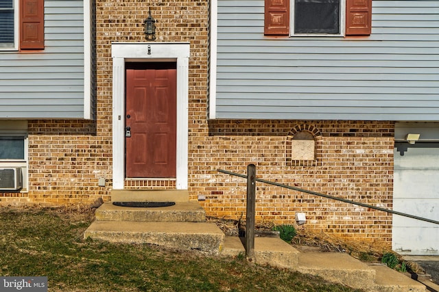 view of exterior entry featuring brick siding