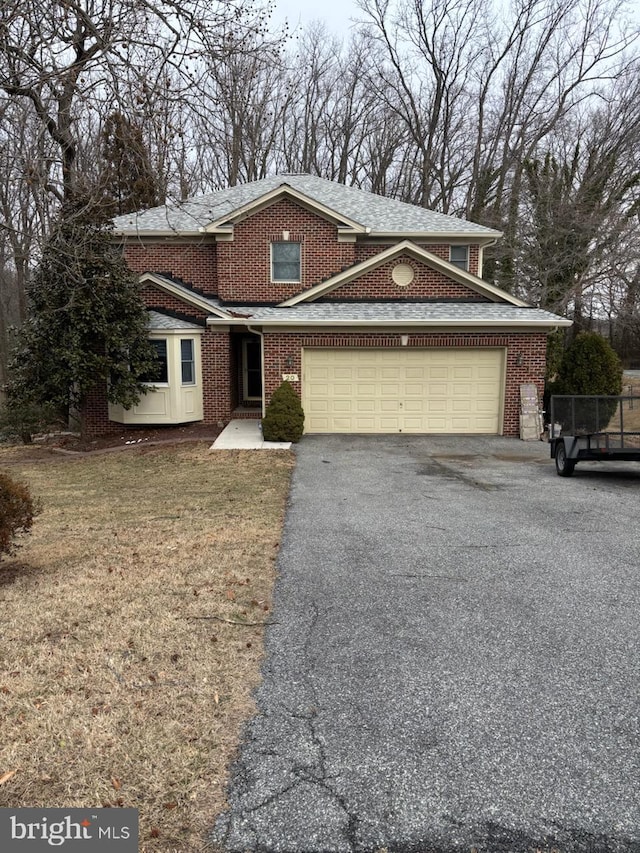 traditional home with a garage, driveway, brick siding, and roof with shingles