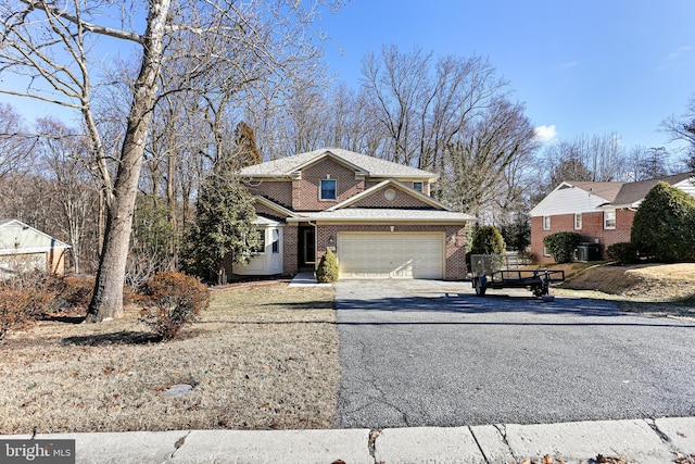 traditional home with aphalt driveway, cooling unit, brick siding, and an attached garage