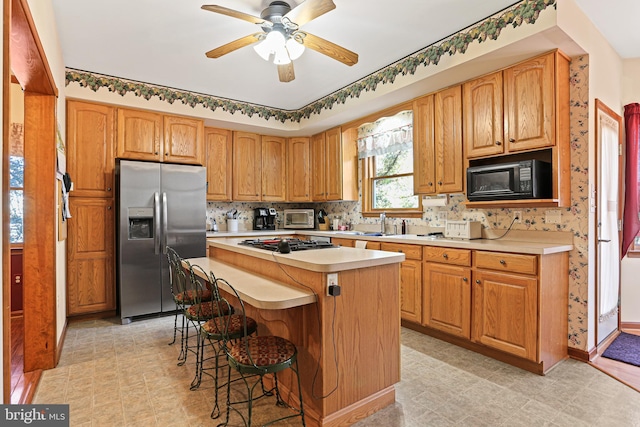 20 Glade Ave, Baltimore, MD 21236 - kitchen with stainless steel fridge with ice dispenser, light countertops, a kitchen island, ceiling fan, and black microwave