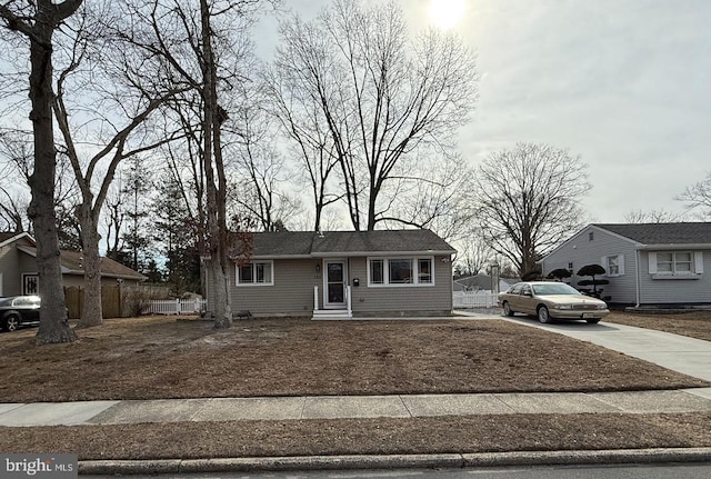 view of front of home featuring concrete driveway and fence