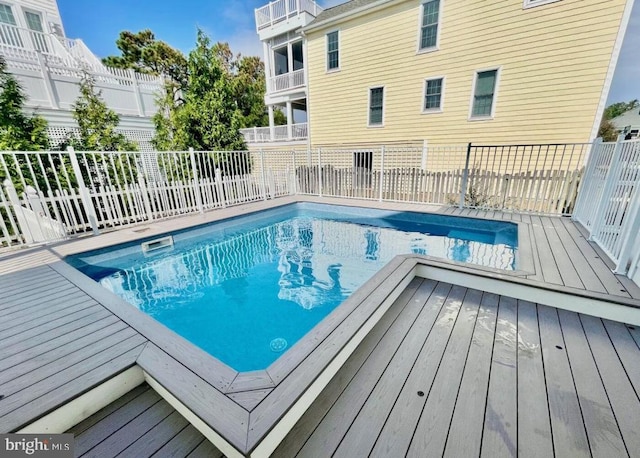 view of swimming pool with a deck, fence, and a fenced in pool