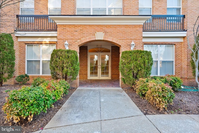 view of exterior entry with brick siding and french doors