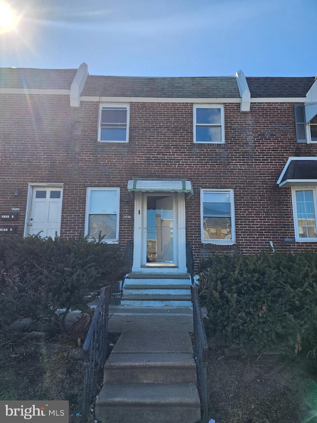 view of property featuring entry steps and brick siding