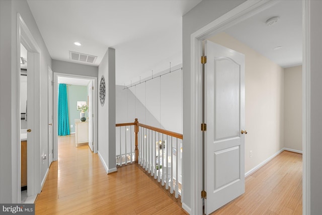 hallway featuring recessed lighting, visible vents, light wood-style flooring, and baseboards