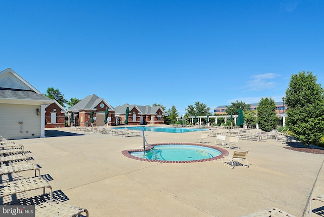 community pool featuring a patio area and a hot tub