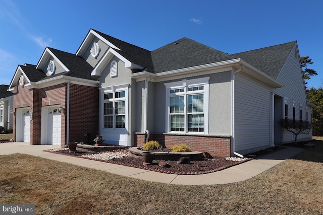 view of front of home featuring a garage, roof with shingles, and brick siding