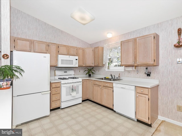 kitchen featuring white appliances, a sink, light countertops, light brown cabinetry, and wallpapered walls