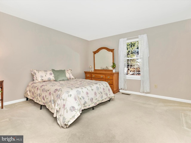 carpeted bedroom featuring visible vents and baseboards