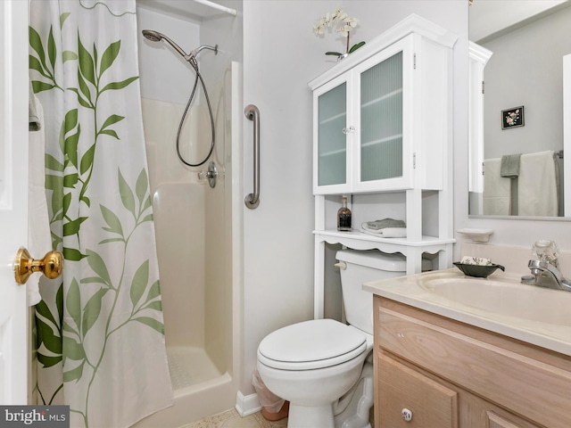 bathroom with toilet, a shower stall, and vanity