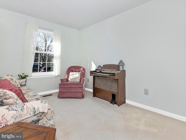 sitting room with carpet flooring, visible vents, and baseboards