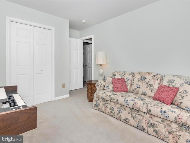 carpeted living area with baseboards