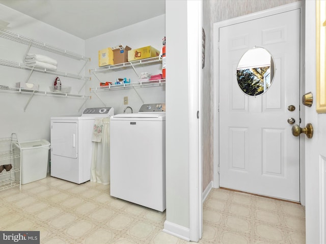 washroom with light floors, independent washer and dryer, laundry area, and baseboards