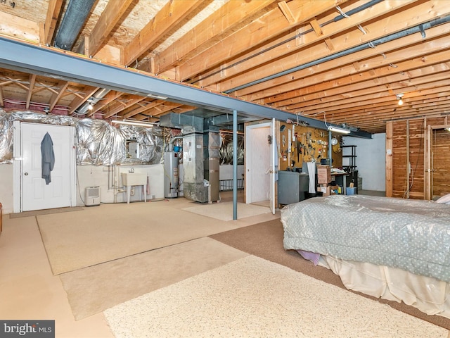 unfinished below grade area featuring gas water heater, a sink, and heating unit