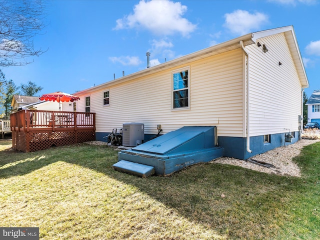 back of house featuring a lawn, cooling unit, and a wooden deck