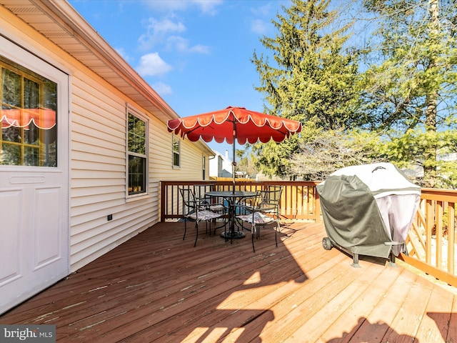 wooden terrace with outdoor dining area and area for grilling