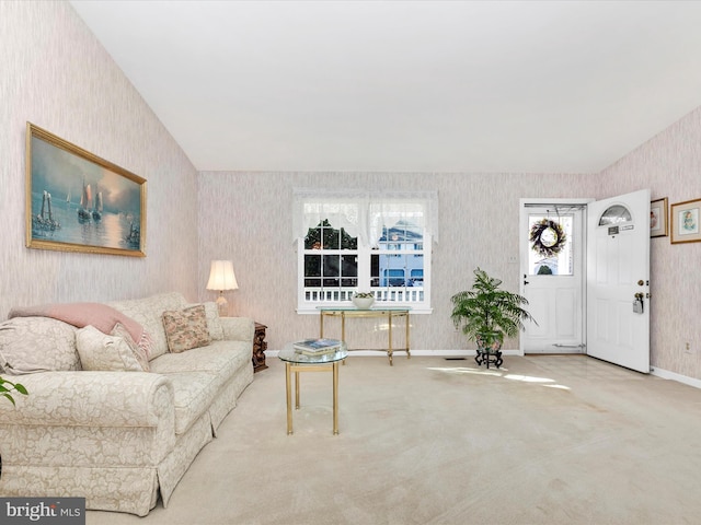 carpeted living area with wallpapered walls and baseboards