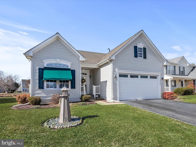 view of front of property with aphalt driveway, a front yard, a shingled roof, and a garage