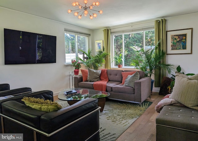 living area featuring a chandelier, baseboards, and wood finished floors