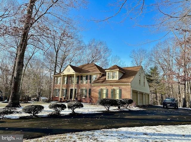 view of front of house with brick siding, driveway, and an attached garage