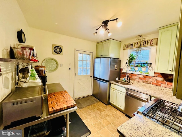 kitchen featuring appliances with stainless steel finishes, light countertops, and a sink