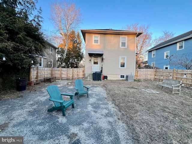 rear view of property with a fenced backyard and central air condition unit