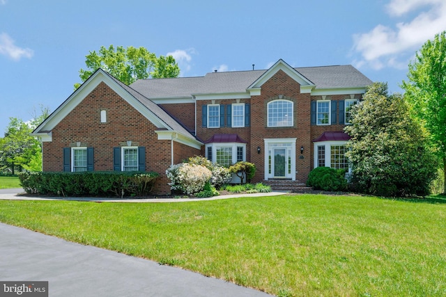 view of front of home featuring a front yard and brick siding