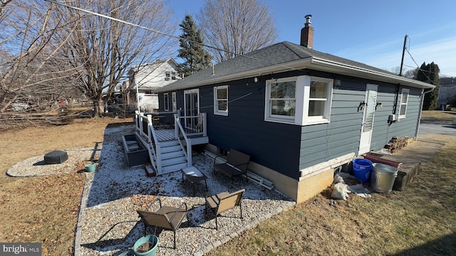 view of home's exterior with a chimney and roof with shingles