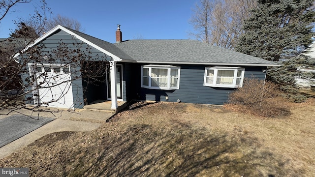 single story home featuring a front yard, roof with shingles, and a chimney