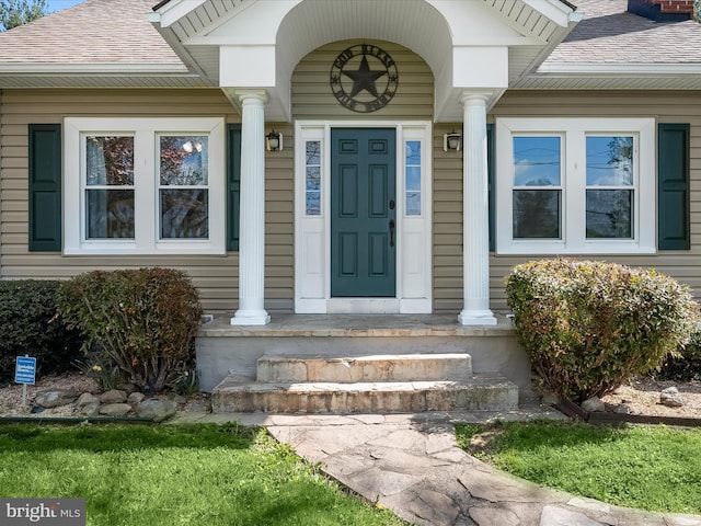 entrance to property with a shingled roof