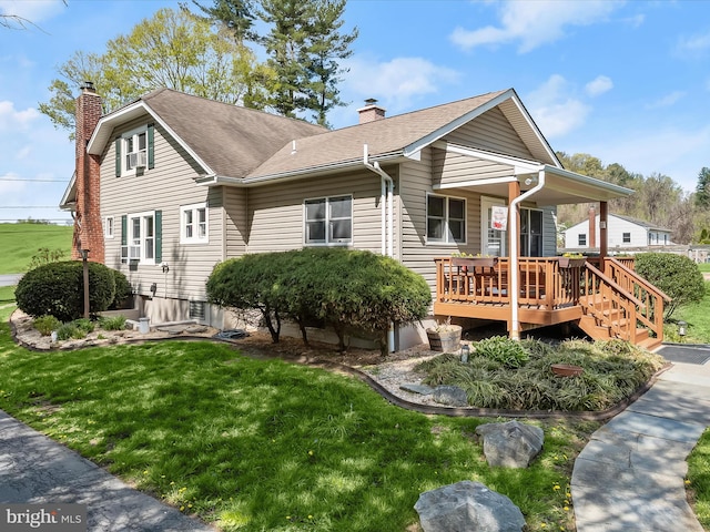 view of front of house with a shingled roof, a chimney, covered porch, and a front yard