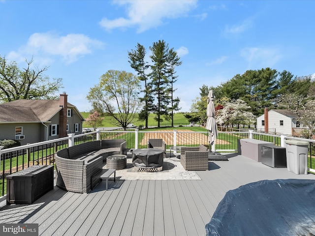 wooden terrace featuring an outdoor living space with a fire pit