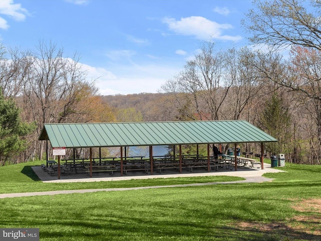 view of community with a gazebo, a yard, and a wooded view