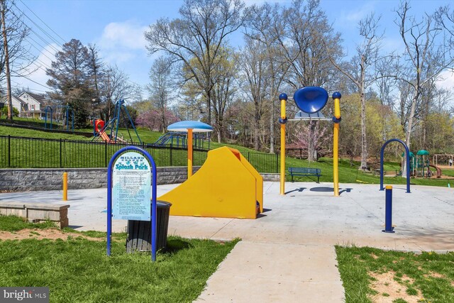 view of property's community featuring fence, playground community, and a yard