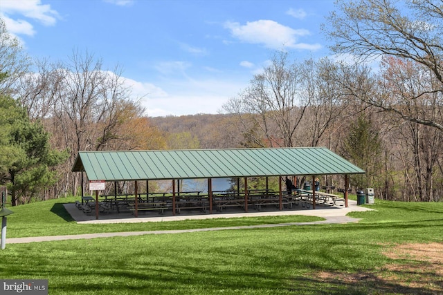 surrounding community featuring a gazebo, a lawn, and a wooded view