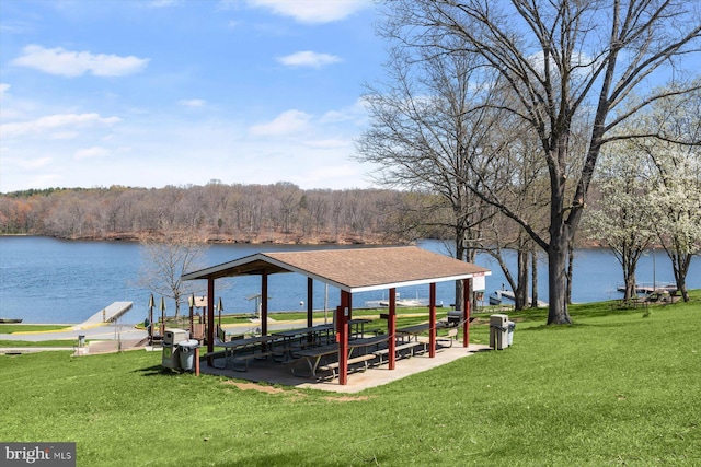 view of dock with a gazebo, a water view, and a yard