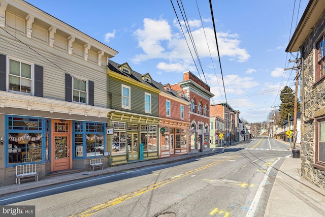 view of street with a residential view, sidewalks, curbs, and street lighting