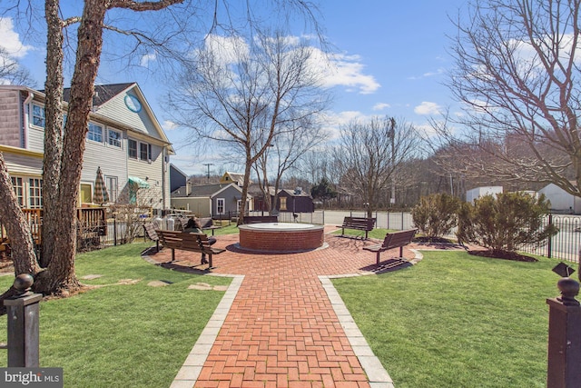 view of community featuring a yard, a residential view, and fence