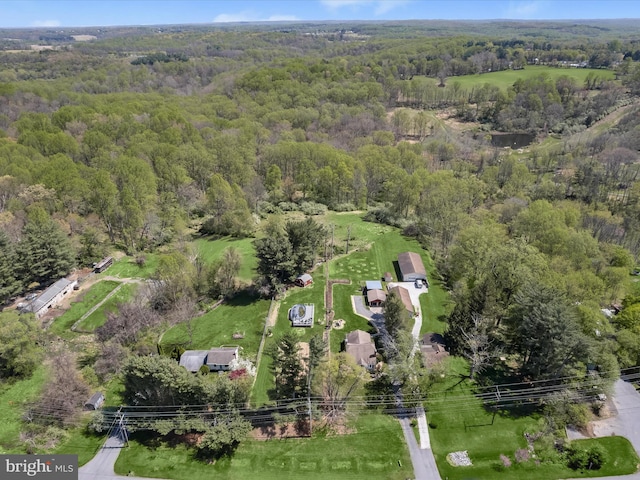 drone / aerial view with a wooded view